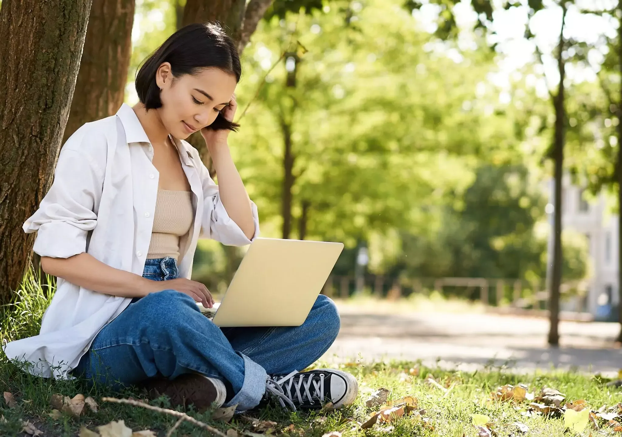 remote-work-smiling-asian-girl-student-doing-homework-remotely-from-park-sitting-with-laptop-near-tr-2048x1439.webp